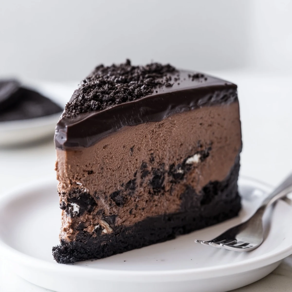Oreo chocolate cheesecake topped with glossy ganache and crushed cookie pieces