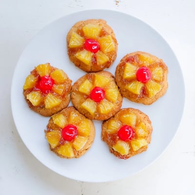 A close-up of a soft Pineapple Upside Down Sugar Cookie reveals moist crumb and rich brown sugar glaze.