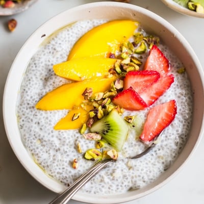 Chilled Coconut Chia Pudding in glass jar, garnished with berries and nuts  